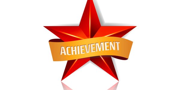 Achievement Vector Star With Yellow Ribbon. Red Sign With Place For Text. Golden Decoration Symbol. 3d Shine Icon Isolated On White